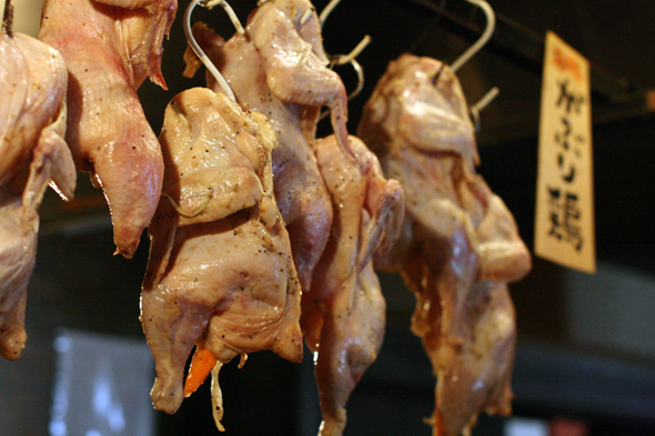 がぶり鶏の旨味を引き出すため吊るされている鶏のアップ写真。余熱で水分と脂を落とす工程。